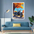 A framed wall art print featuring a blue motorcycle under orange autumn trees, displayed above a blue sofa in a modern living room setting.
