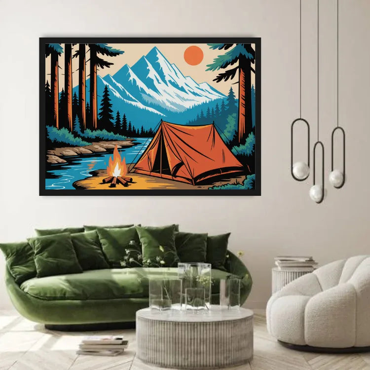 A framed art print depicting a mountain camping scene with an orange tent, campfire, river, and pine trees, displayed on a beige wall above a green velvet sofa in a modern living room setting.