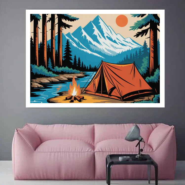 A framed art print depicting a mountain camping scene with a tent, campfire, river, and pine trees, displayed on a gray wall above a pink sofa.