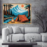 A framed art print depicting a retro-style camping scene with an orange tent, campfire, blue river, and snow-capped mountains, displayed on a gray concrete wall above a white sofa.