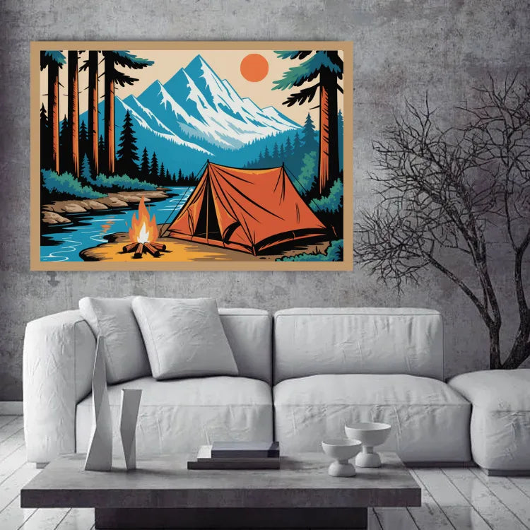 A framed art print depicting a retro-style camping scene with an orange tent, campfire, blue river, and snow-capped mountains, displayed on a gray concrete wall above a white sofa.