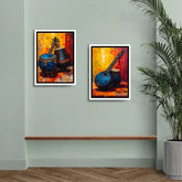 Two framed paintings of musical instruments on a wall with a plant and wooden shelf.