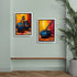 Two framed paintings of musical instruments on a wall with a plant and wooden shelf.
