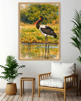 Framed painting of a stork by a lake in a living room setting with a chair and plant.