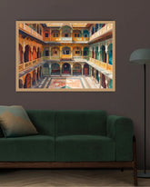 A framed art print depicting a colorful courtyard with arches and balconies, displayed on a dark wall above a green sofa in a modern living room setting.