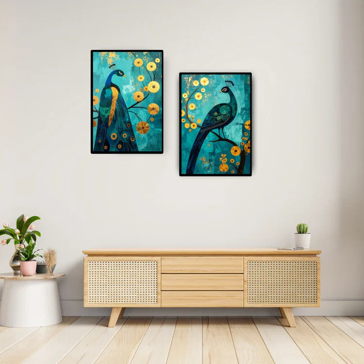 Two framed paintings of peacocks on a wall above a wooden cabinet.