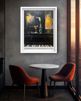 A framed abstract art print depicting a piano and cocktail glass, displayed on a gray wall above a small round table and two red chairs in a modern dining room setting.