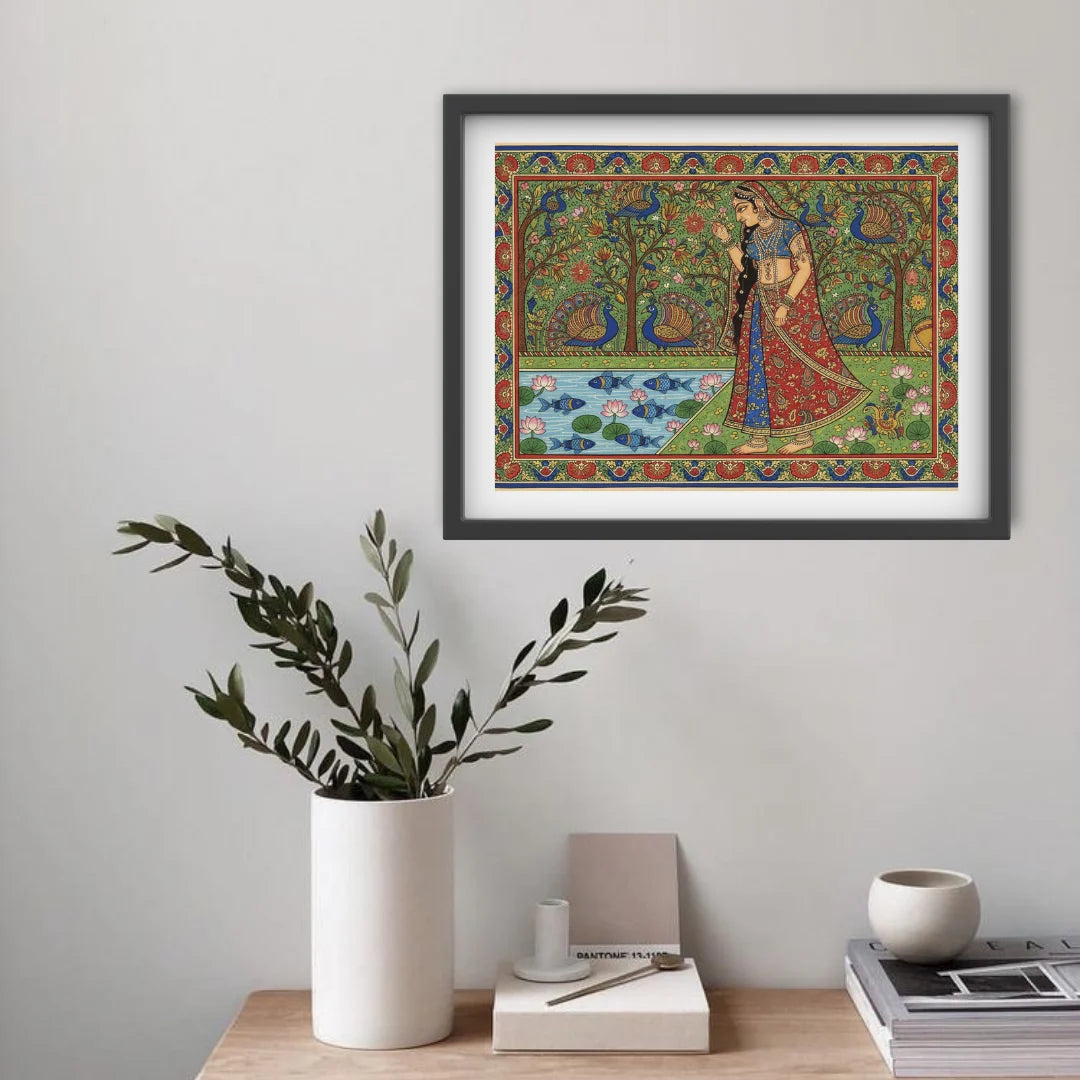 Framed artwork of a woman in traditional attire with peacocks, above a table with decor items.