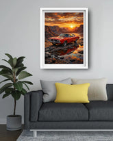A framed art print of a red muscle car in a desert canyon at sunset, displayed on a light gray wall above a modern gray sofa with yellow and white pillows.