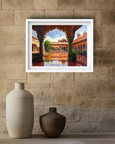 A framed art print depicting a traditional Indian courtyard with arches and a reflecting pool, displayed on a beige stone wall above two ceramic vases.