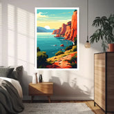 A vertical framed art print featuring a colorful coastal landscape with turquoise water, orange cliffs, and a bright sky, displayed on a bedroom wall above a wooden nightstand.