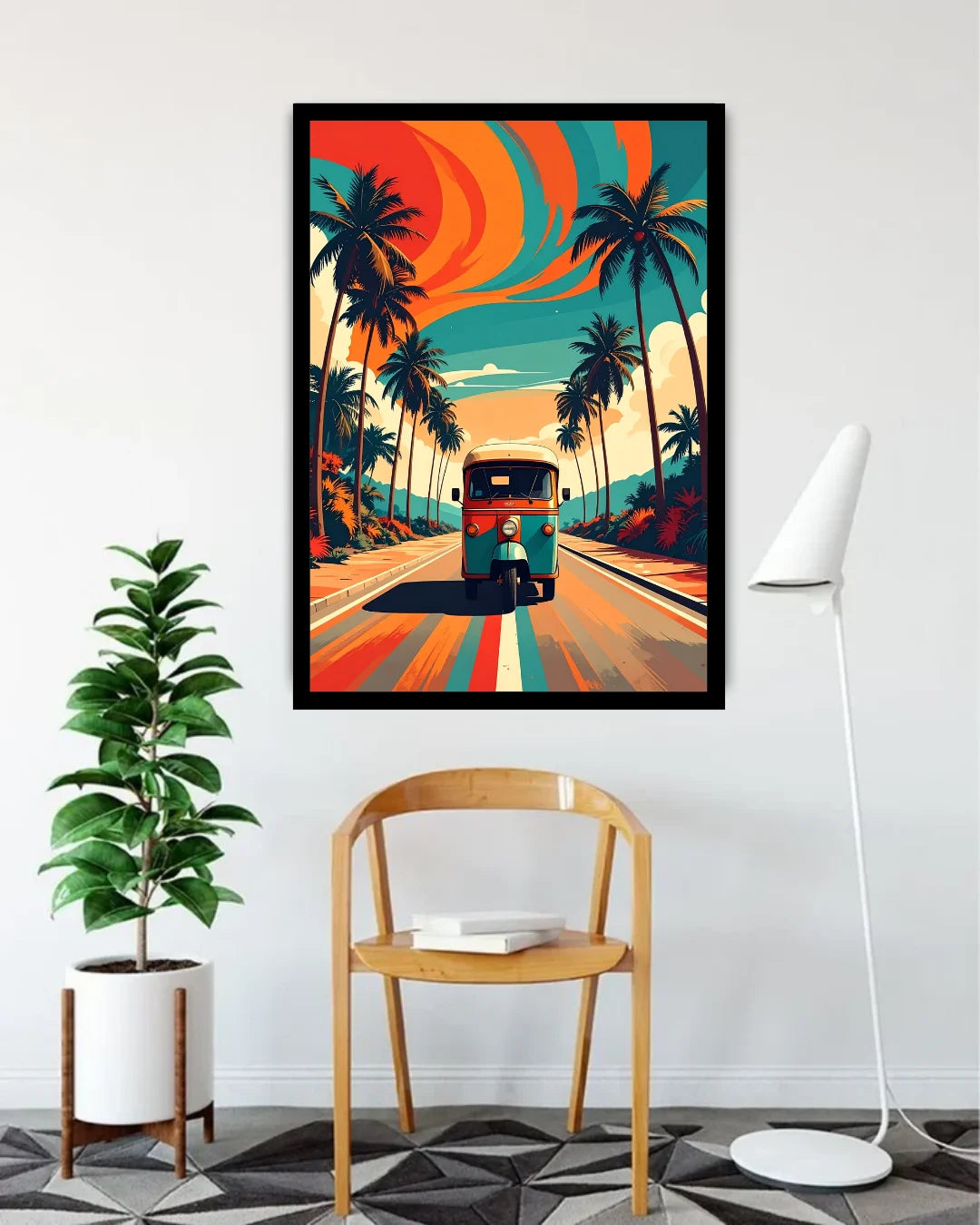 A framed vertical art print featuring a retro bus on a tropical road lined with palm trees under a vibrant orange and teal sky, styled in a modern room above a wooden chair next to a potted plant and floor lamp.