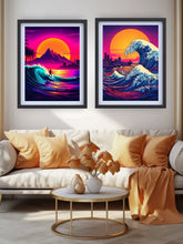 Two framed retro-futuristic art prints hanging side-by-side above a beige sofa in a modern living room. The prints feature vibrant neon waves, a large orange sun, and a city skyline, styled with gold and orange pillows and a gold coffee table.