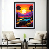 A framed art print featuring a retro blue muscle car on a sunset road trip with palm trees and mountains, displayed on a white wall above two modern beige armchairs.