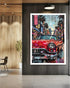 Framed artwork of a red classic car in an urban setting on a wall.