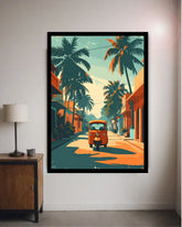 A framed art print depicting a retro orange auto-rickshaw on a tropical street lined with palm trees, displayed on a light gray wall in a modern room setting next to a lamp.