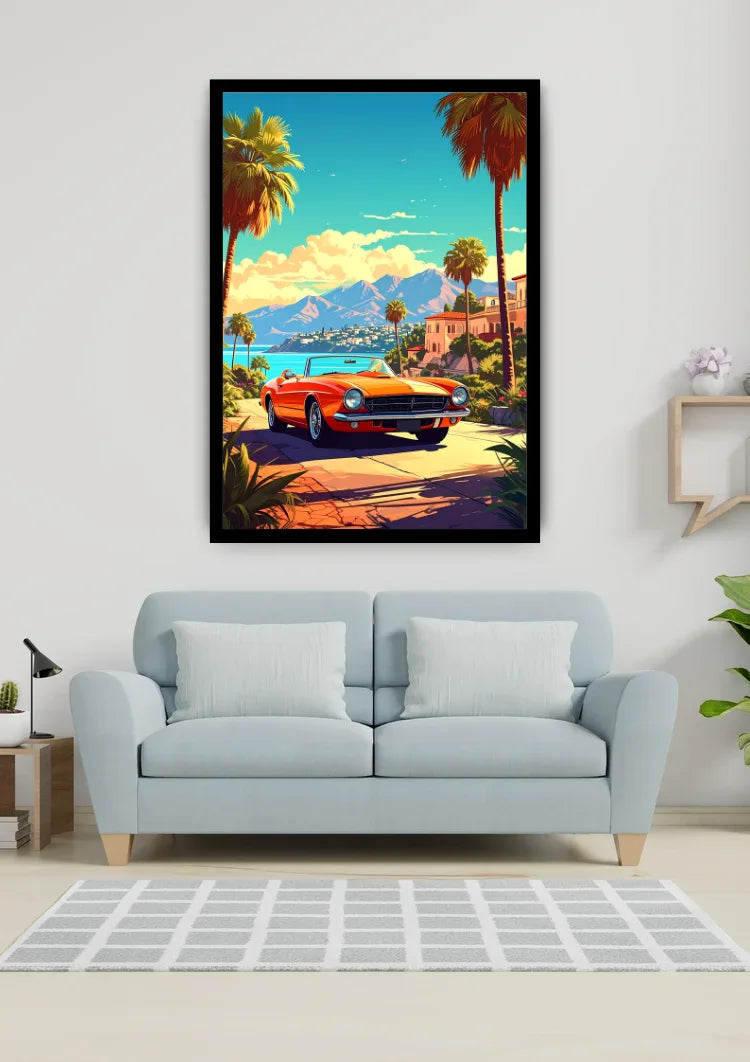 A framed vertical art print depicting a retro orange convertible car on a coastal road lined with palm trees, displayed on a light gray wall above a light blue sofa in a modern living room setting.