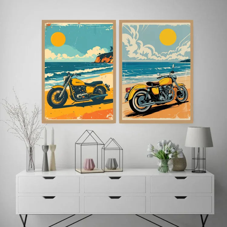 Two framed vintage-style beach motorcycle posters displayed side by side on a light gray wall above a white console table with decorative vases, candles, and a lamp.