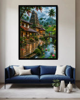 A large framed wall art print depicting a lush tropical temple scene with a river, bridge, and palm trees, displayed above a blue sofa in a modern living room setting.