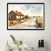 Framed landscape painting of a rural scene with a house and road on a white wall.
