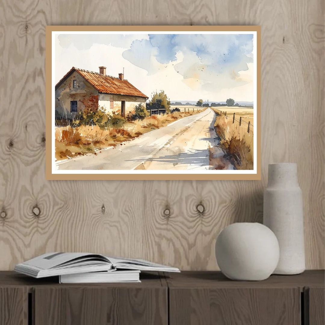 Framed painting of a rural landscape with a house on a wooden wall above a cabinet.