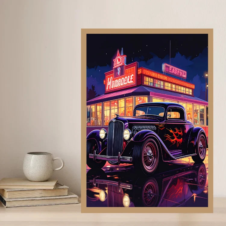 A framed art print depicting a retro hot rod car at night in front of a neon-lit diner, styled on a shelf next to a ceramic mug and books.