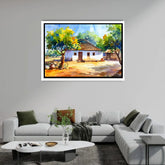 Framed landscape painting of a rural scene above a modern living room setup.