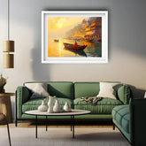 A framed art print depicting a golden sunset over a river with a small boat and ghats, displayed on a gray wall above a green sofa in a modern living room setting.