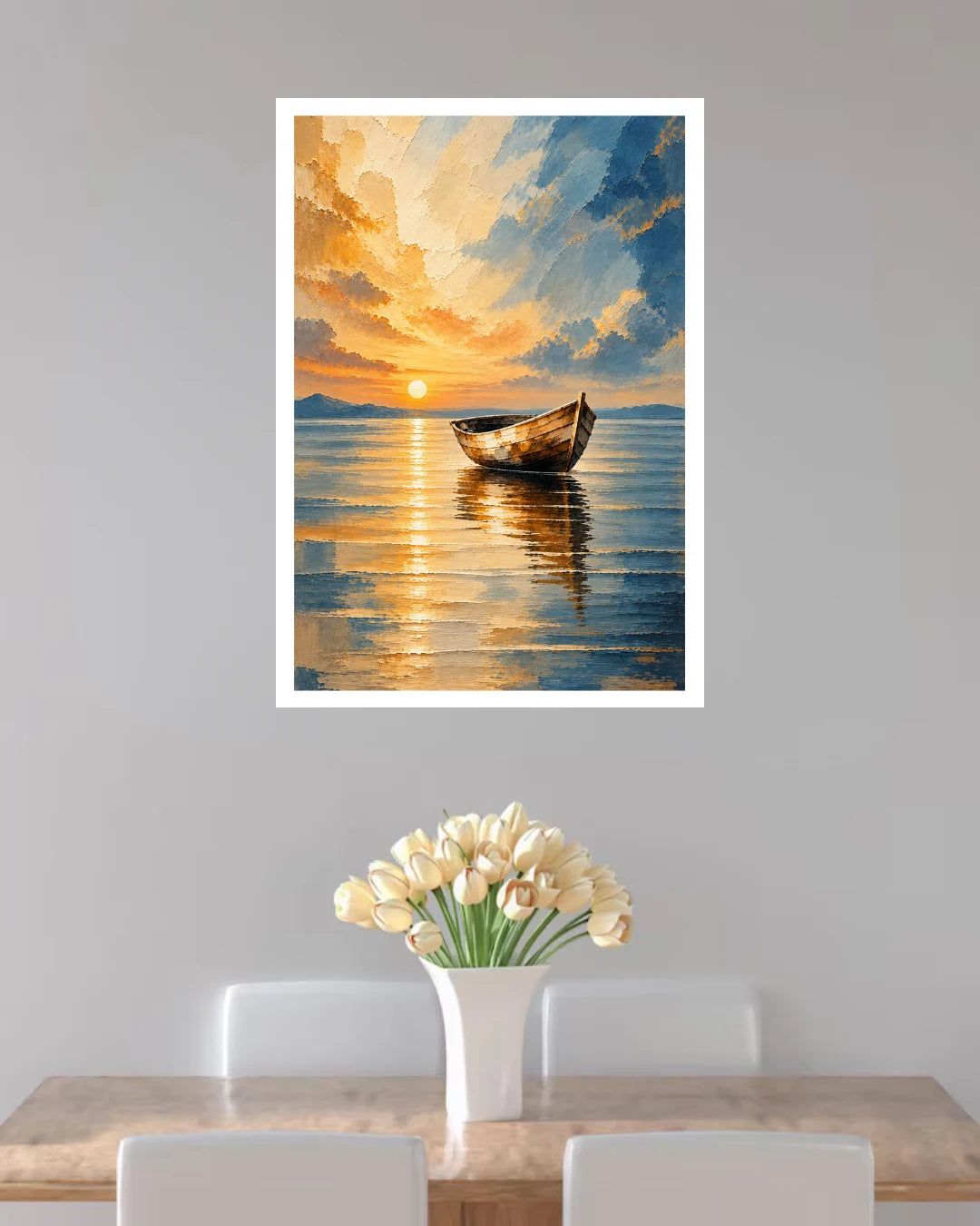 A framed vertical art print depicting a serene sunset over a calm lake with a small boat, displayed on a light gray wall above a dining table with white chairs and a vase of tulips.