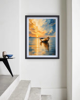 A framed art print depicting a serene sunset over a calm lake with a small boat, displayed on a white wall in a minimalist interior setting.