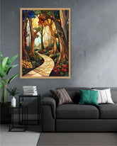 A framed vertical art print depicting a winding stone path through a dense, colorful forest, displayed on a gray wall above a dark gray sofa in a modern living room setting.
