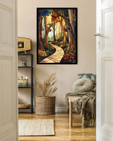 A framed vertical art print depicting a winding stone path through a sunlit forest, displayed on a beige wall in a styled room with a chair, basket, and shelving.