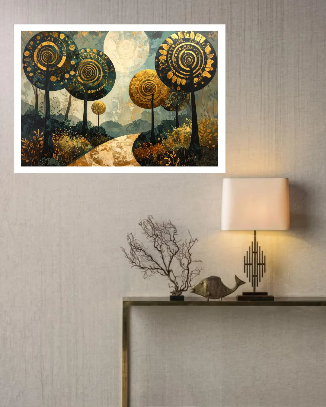 A framed wall art print featuring stylized golden trees and a moonlit landscape, displayed on a textured light gray wall above a console table with a lamp and decorative branches.