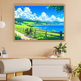 A framed landscape art print depicting a sunny lakeside scene with green fields, blue sky, white clouds, and a bicycle, displayed on a beige wall above a wooden console table in a modern room setting.