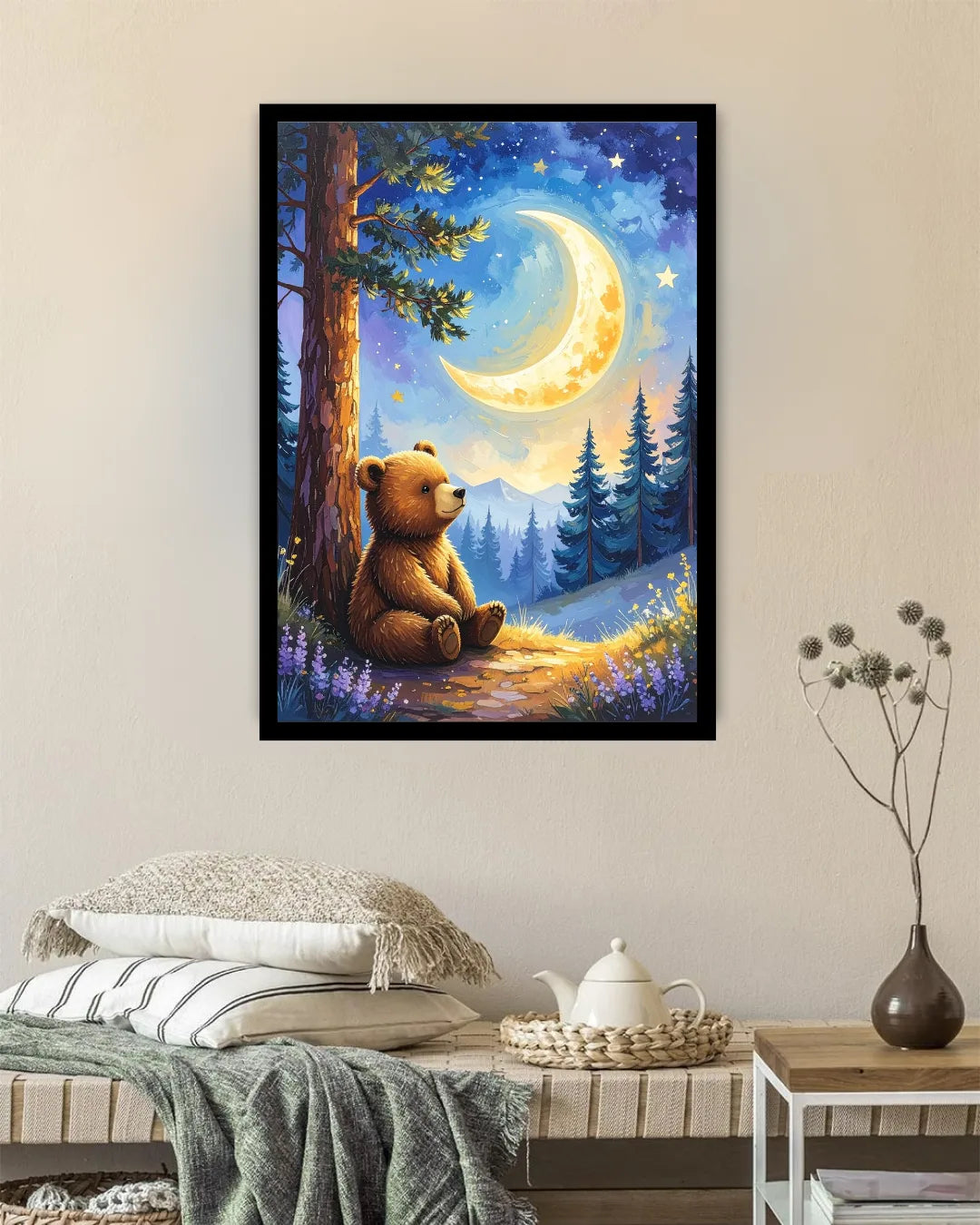A framed art print depicting a cozy night scene with a teddy bear under a glowing crescent moon, displayed on a beige wall above a bed in a styled bedroom setting.