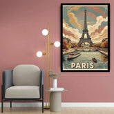 A framed vintage-style Paris poster hanging on a dusty pink wall in a modern living room setting, next to a gray armchair and a gold floor lamp.