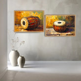 Two framed paintings of traditional drums hanging on a light gray wall above two white ceramic vases.