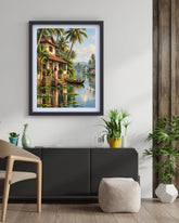 A framed art print depicting a tropical lake scene with palm trees, a house, and a boat, displayed on a white wall above a dark gray sideboard in a modern living room setting.