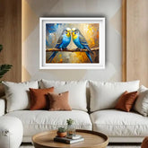 Framed artwork of two blue parakeets on a branch above a white sofa with brown cushions.