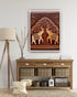 Framed artwork of two elephants under a tree on a wall above a wooden console table.