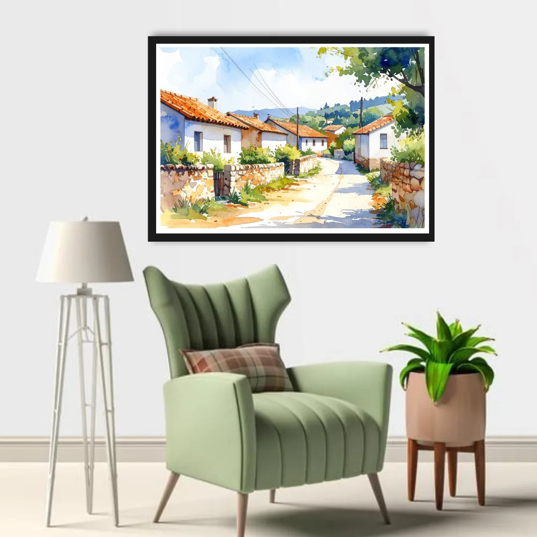 Framed painting of a village scene above a green armchair with a lamp and plant in the room.