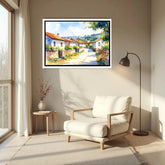Living room with a white armchair, side table, and framed painting of a village scene.