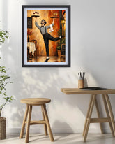 A framed art print featuring a whimsical painting of a woman in a striped shirt balancing wine glasses on trays in a warm-toned restaurant, displayed on a white wall above a wooden table and stool.