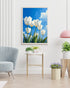 White tulip floral wall art canvas displayed in a bright modern interior with chair and plant
