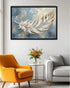 Framed abstract painting of a feather in a living room with a yellow armchair and gray sofa.