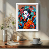 Colorful abstract portrait of a woman in a white frame on a wall above a wooden table with a cup and vase.