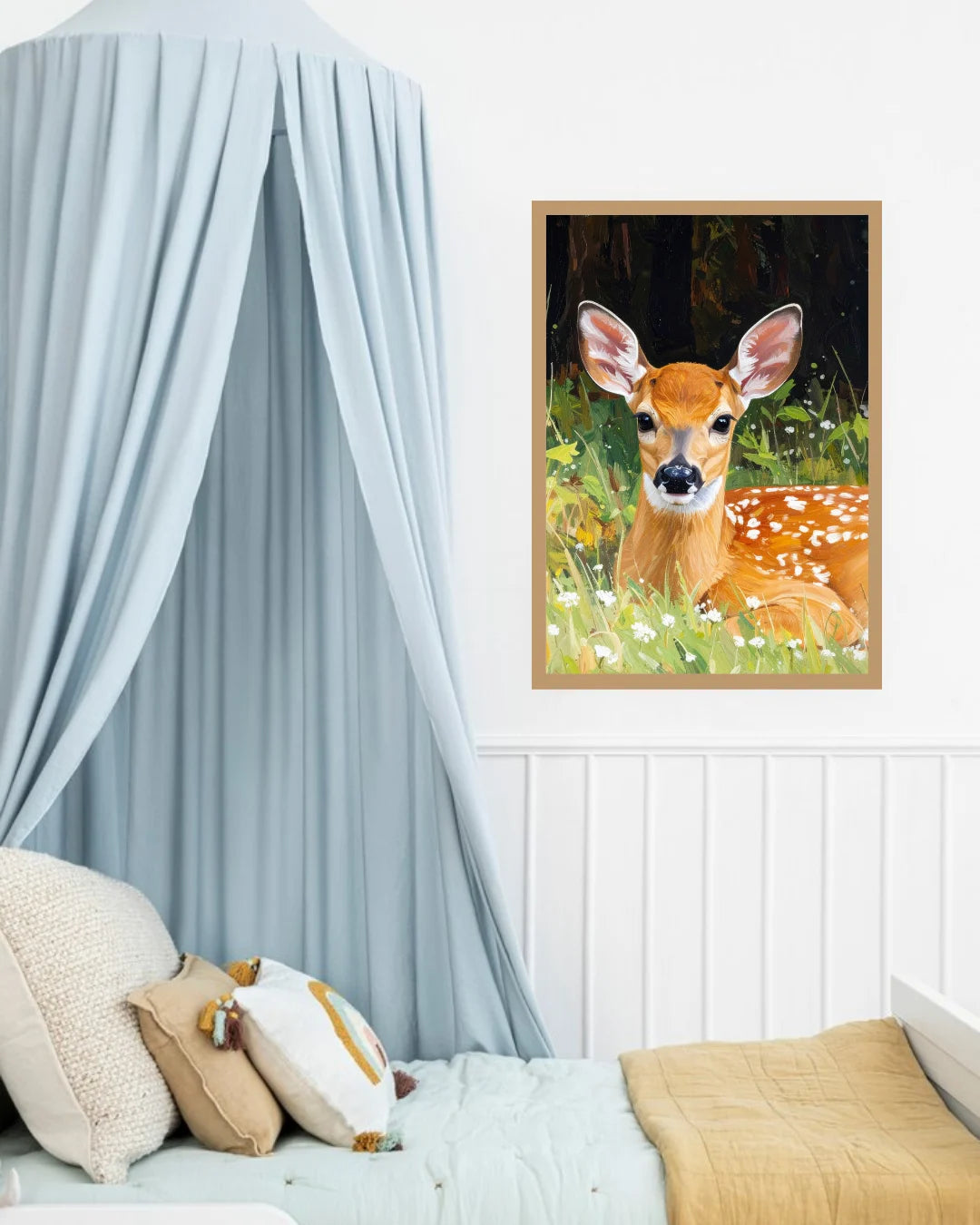 A framed art print of a cute deer in a forest meadow, styled on a white wall above a bed with a light blue canopy and neutral-toned bedding.